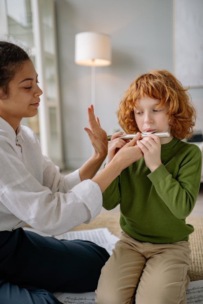 A young boy receives flute lessons from a teacher at home, fostering musical skills.