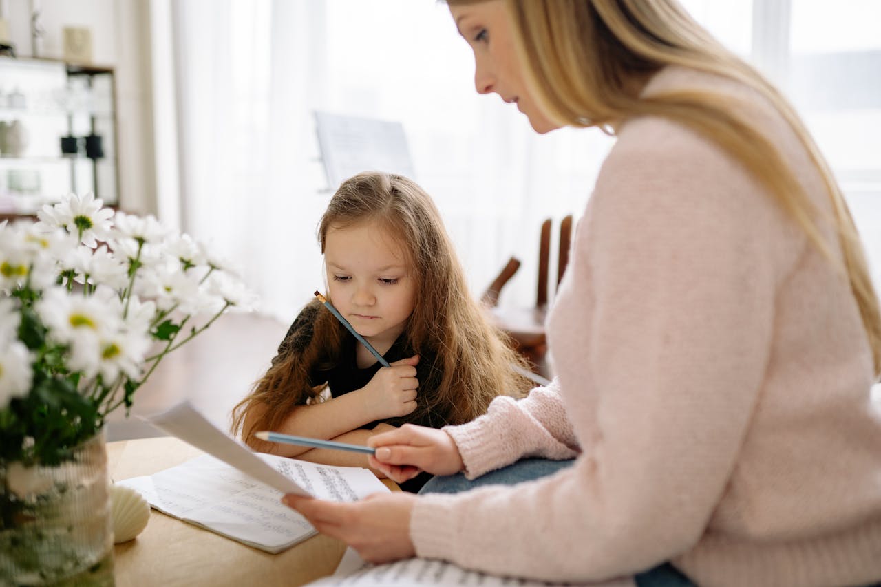 A mother and daughter learning piano together at home, fostering musical education and bonding.